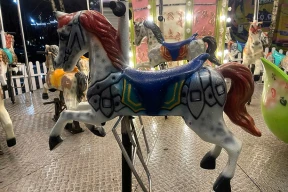 Новогодняя детская карусель по соседству с рекламой азартных игр